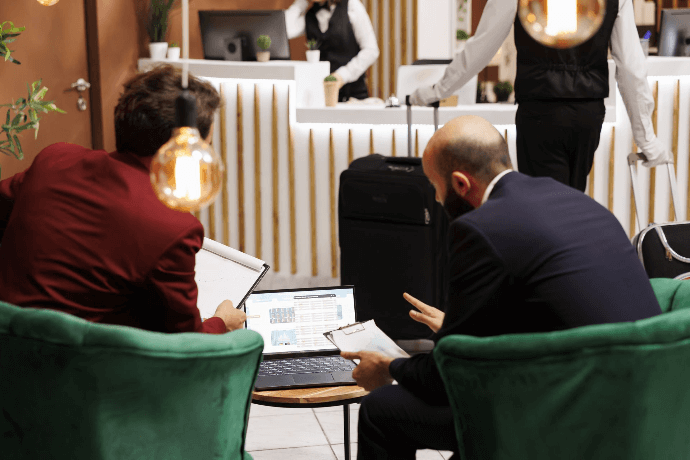 Cliente reservando hotel en ordenador en recepción Cliente reservando hotel en ordenador en recepción