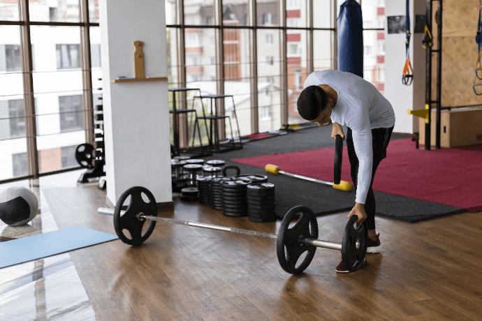 Hombre preparándose para levantar pesas en gimnasio Hombre preparándose para levantar pesas en gimnasio