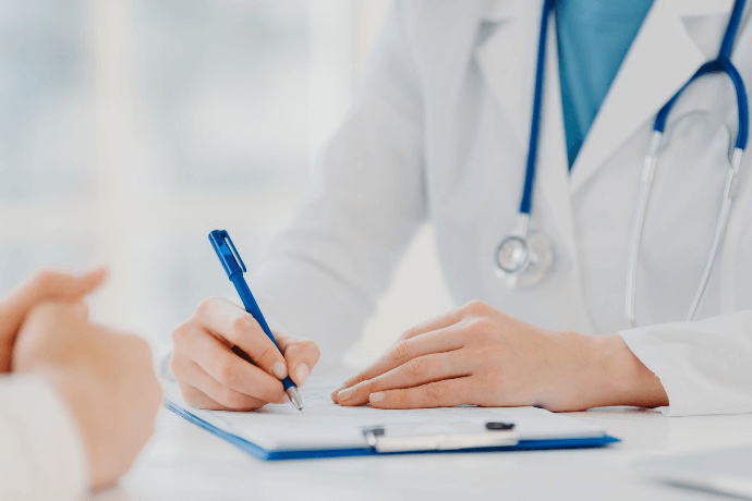 Médico tomando notas durante consulta con paciente Médico tomando notas durante consulta con paciente